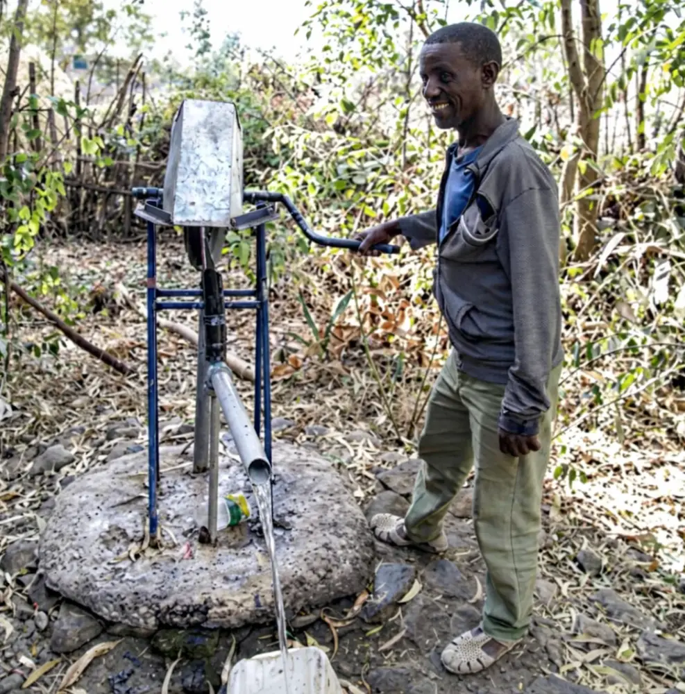 Mossa Alemu beside the rope-and-washer pump on his well, Shebel Berenta